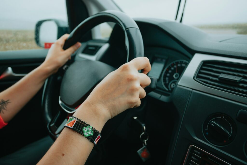 close up of hands on stearing wheel driving van